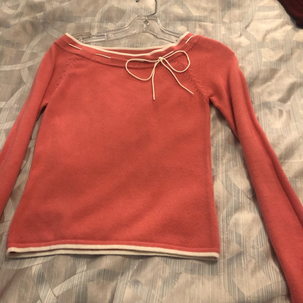 Pink sweater with white trim and bow detail